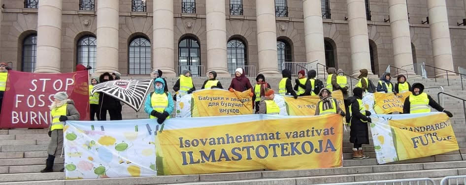 Ilmastoisovanhemmat osoittavat mieltä Helsingissä Eduskuntatalon portailla.